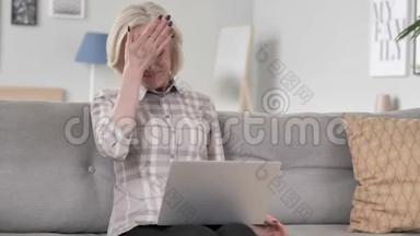 失落、沮丧的老妇人在笔记本电脑上工作